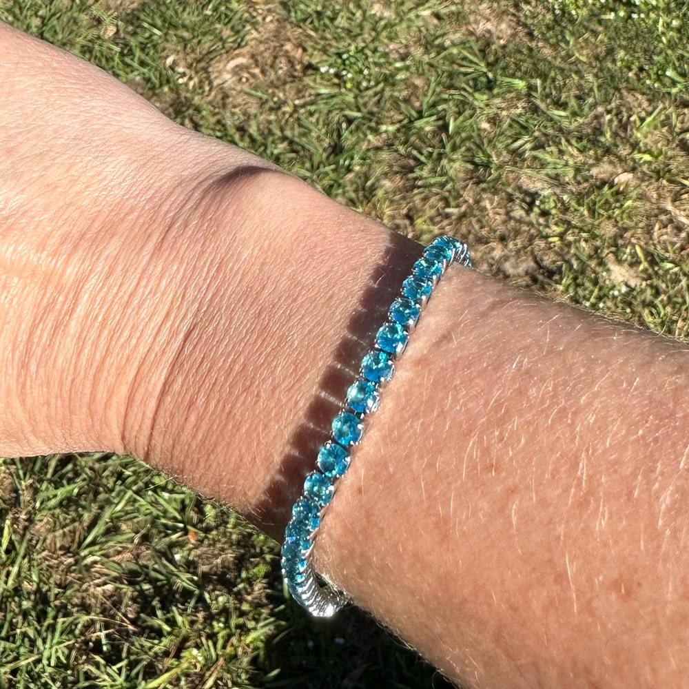 Brand new 7.5” silver tone, blue stone tennis bracelet.